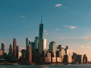 One World Trade Center rising above the Lower Manhattan skyline at sunset, viewed from across the Hudson River
