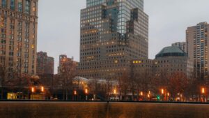9/11 Memorial pool at the World Trade Center with Lower Manhattan skyline at dusk